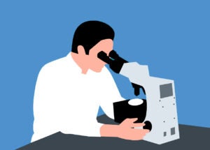 Scientist looking into a microscope during a clinical trial