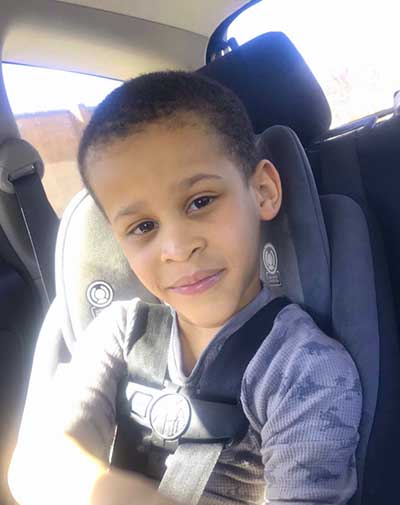 A young boy, Seth Newman, sitting in a carseat with his seatbelt on.