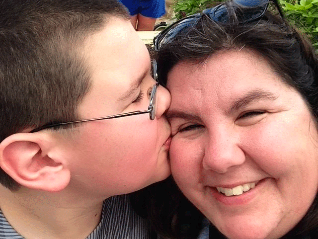 Missy's son kissing her on the temple.
