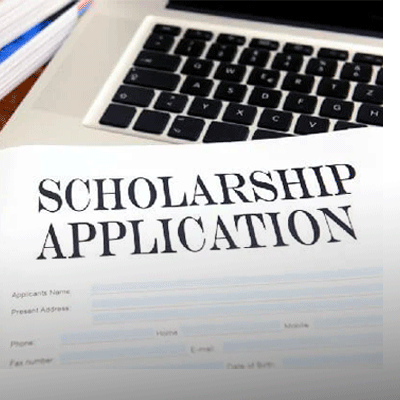 Scholarship Application form laying atop a laptop computer keyboard.