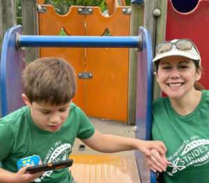 A mom and her son in a playground wearing X Strides t-shirts.