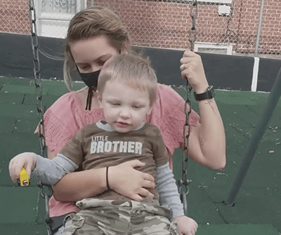 Jeriko and mom on a swing outdoors