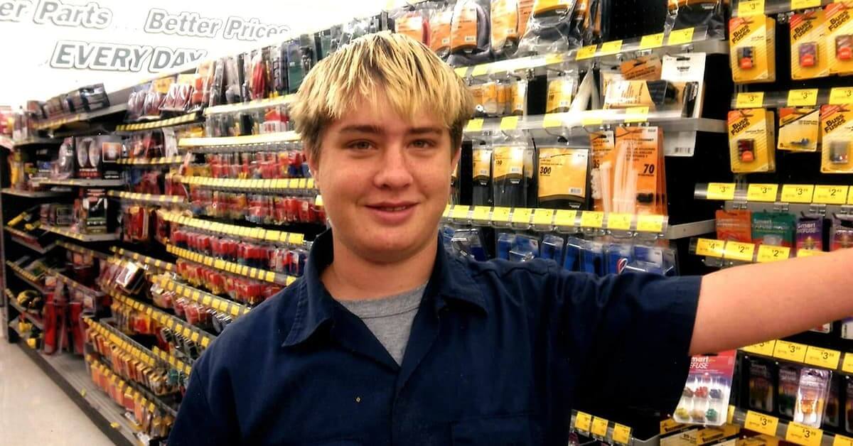A blonde male young adult working at an auto parts store