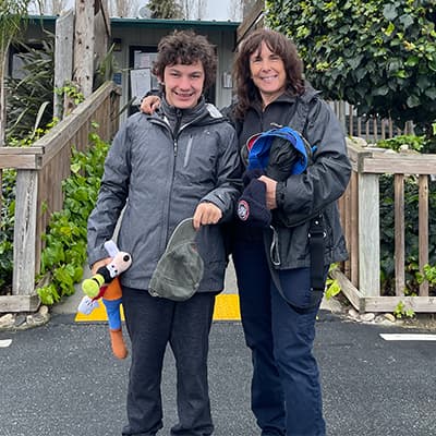 Zach and his mom standing in front of the Monterey Zoo entrance gate